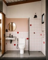 Un baño pequeño con inodoro, lavabo y ducha.