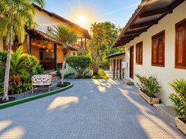Un patio con un sendero empedrado, un banco y varias plantas.