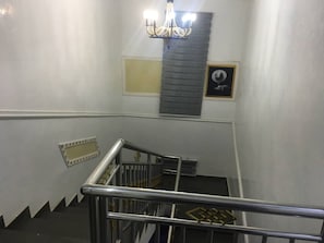 A staircase with metal railings and a chandelier.