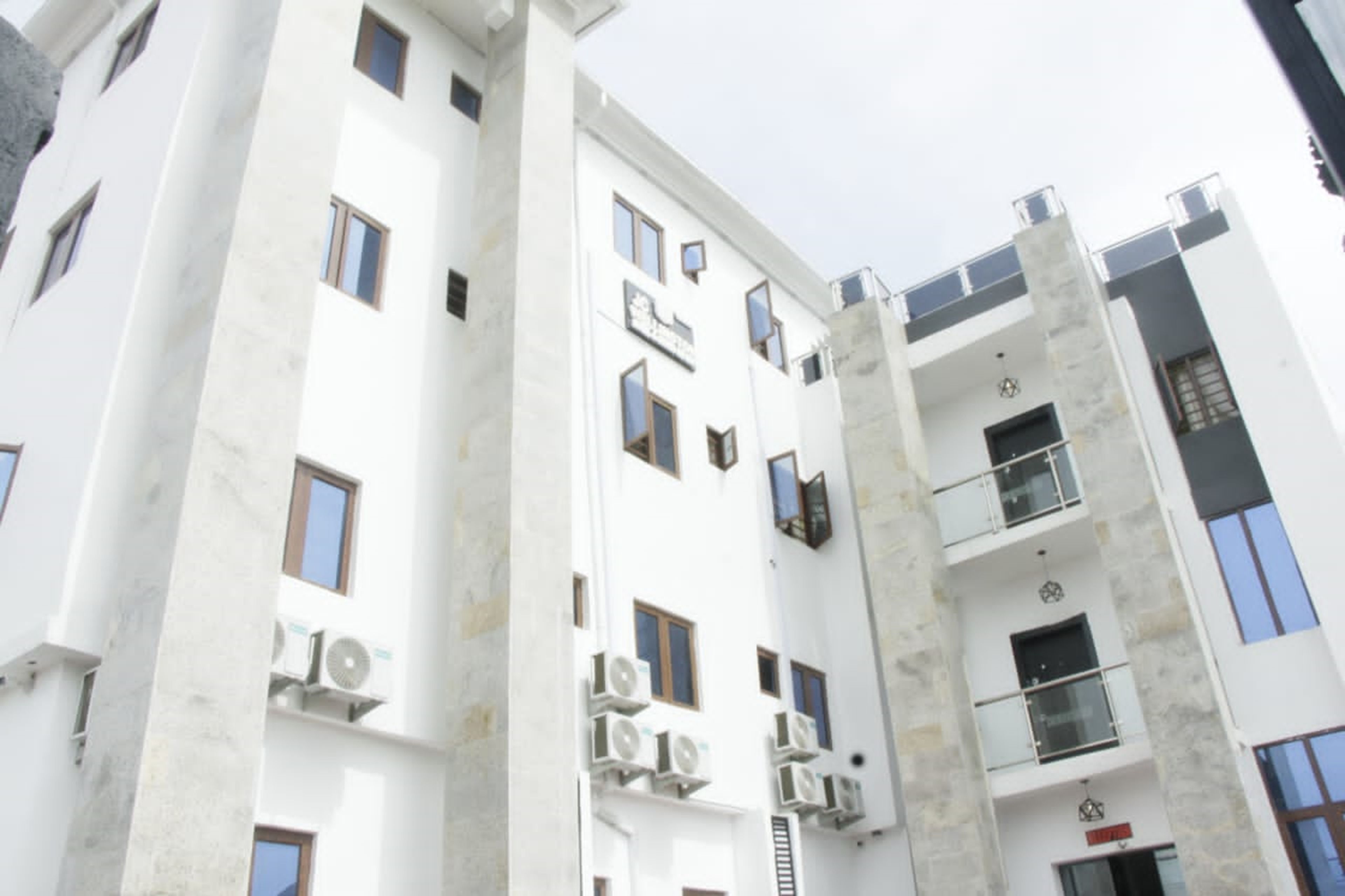 Un edificio a più piani con balconi, condizionatori d'aria e cielo sereno.