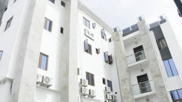 Un edificio a più piani con balconi, condizionatori d'aria e cielo sereno.