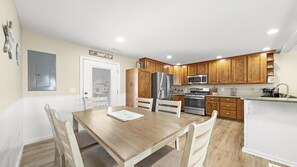 A compact kitchen with wooden cabinets, a stainless steel refrigerator, a microwave, and a stove. - Large cape close to the beach & bay . Easy on & off the Island (Ship Bottom)