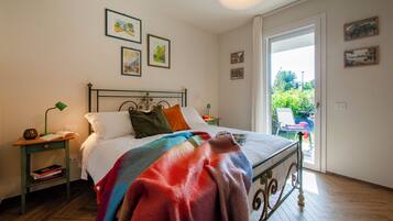 Een slaapkamer met een bed, nachtkastjes, een raam en kunstwerken aan de muren.