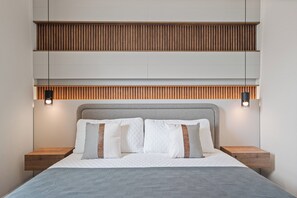 A modern bedroom with a bed, two bedside tables, and a built-in shelf above the bed. - Brand New Disney-Themed 8BR Home | Windsor Cay (Clermont)