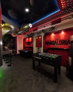 Ein Zimmer mit Kicker, Barbereich und einer Wand mit 'The Mandalorian'-Branding.
