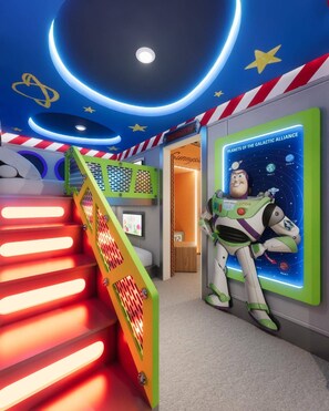 Ett rum med ett rymdtema, inklusive en karta över ett rymdområde, en affisch med Buzz Lightyear och en trappa med röda och gula lampor.