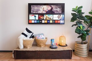 A flat-screen TV mounted on a wall displaying various streaming services and a live channel. - Fabulous 5-bedroom apartment in charming Providencia neighborhood (Providencia)