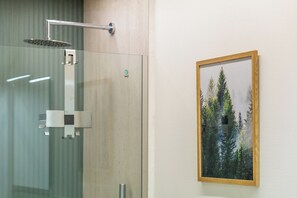 A shower with a glass enclosure and a framed picture of trees on the wall. - Civico Due - Apartment (Cuneo)