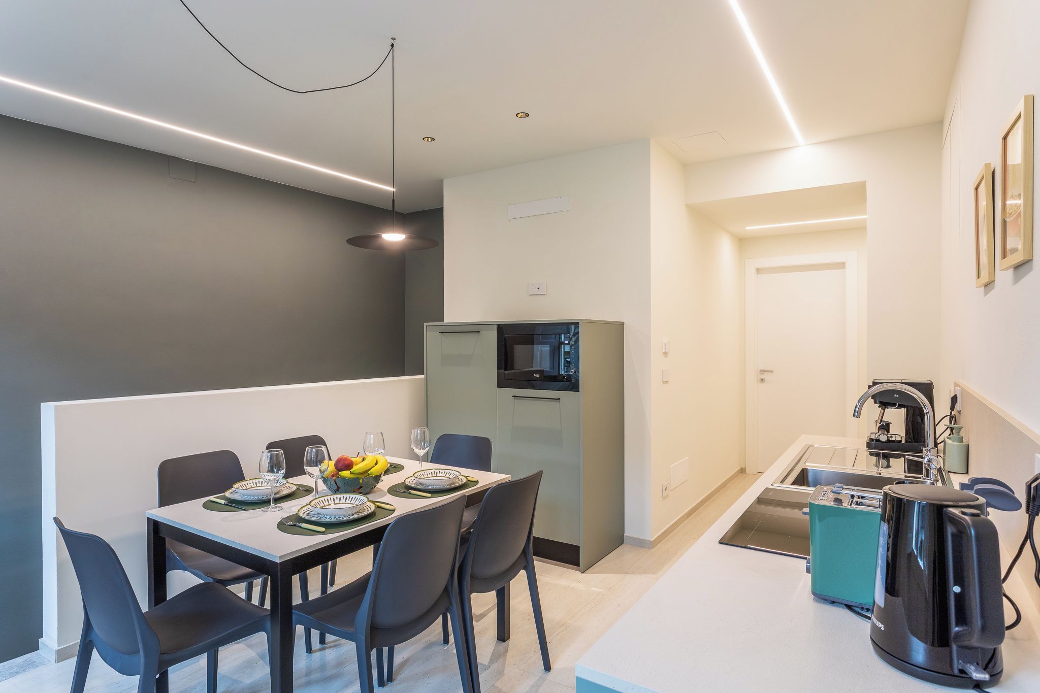 A modern kitchen with a built-in microwave, a coffee machine, and a sink.