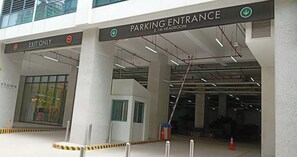 Ein Parkeingang mit einem Schild, das 'AUSFAHRT NUR' und 'PARKING EINFAHRT 2,1 M GEHÖHENBEGRENZUNG' anzeigt.