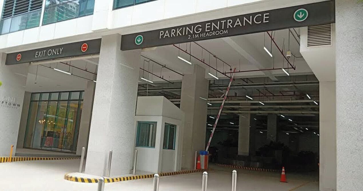 A parking entrance with a sign indicating 'EXIT ONLY' and 'PARKING ENTRANCE 2.1M HEADROOM'.