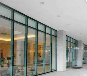 A modern building with large glass windows and a clean, minimalist interior design. - One Uptown Residence 31O (Taguig City)