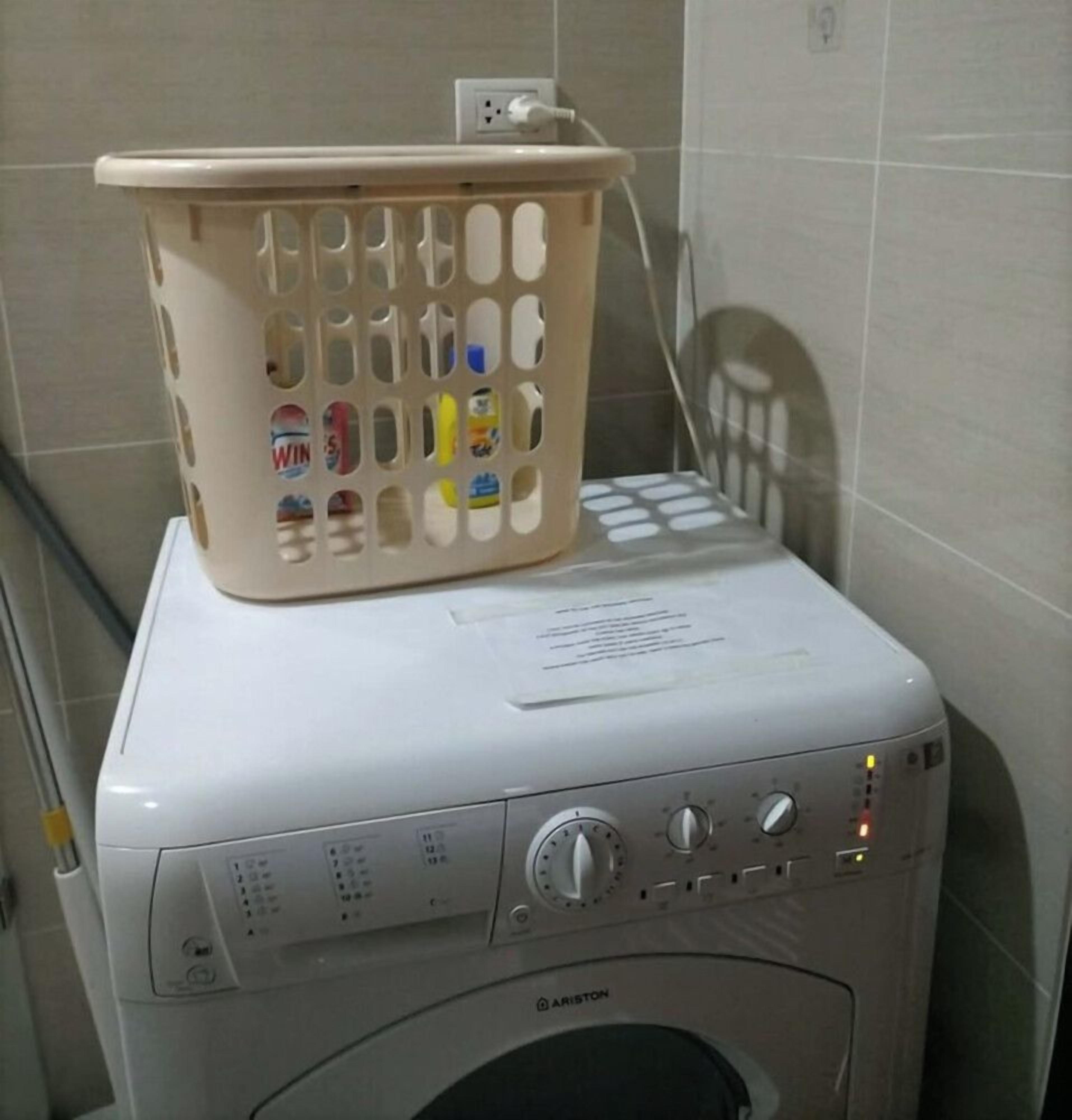 A front-loading washing machine with a basket on top.