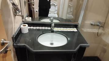 A bathroom with a black sink, a mirror, and a toilet.