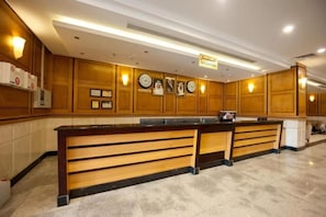 A reception area with a reception desk, clocks, and a sign indicating the reception. - Al-Fajr Al-Badi Hotel 5 (Makkah)