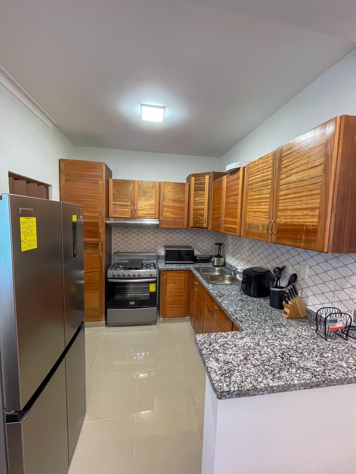 A kitchen with wooden cabinets, stainless steel appliances, and a granite countertop.