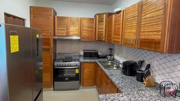 A kitchen with wooden cabinets, stainless steel appliances, and a granite countertop.