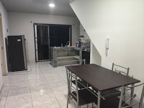 Cocina compacta con comedor, que incluye refrigerador, pileta y estufa.