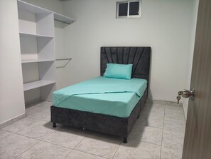 A bedroom with a bed, a window, and built-in shelving. - MORADA CELESTIAL HOUSE is an apartment, perfect for family outings. (Ibagué)