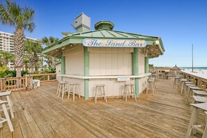 A wooden deck with a bar named 'The Sand Bar' and several stools. - St Croix's Finest ☀️Remodeled 3BR Beachfront⛱️HGTV Worthy🐟Silver Shells😎Amenities🌴 (Destin)