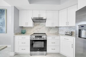 A modern kitchen with white cabinetry, a stainless steel oven, and a water dispenser. - St Croix's Finest ☀️Remodeled 3BR Beachfront⛱️HGTV Worthy🐟Silver Shells😎Amenities🌴 (Destin)