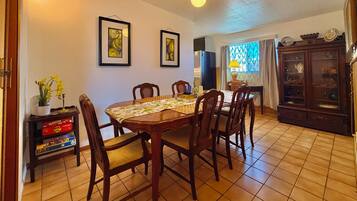 A dining area with a wooden table, chairs, and a tiled floor.