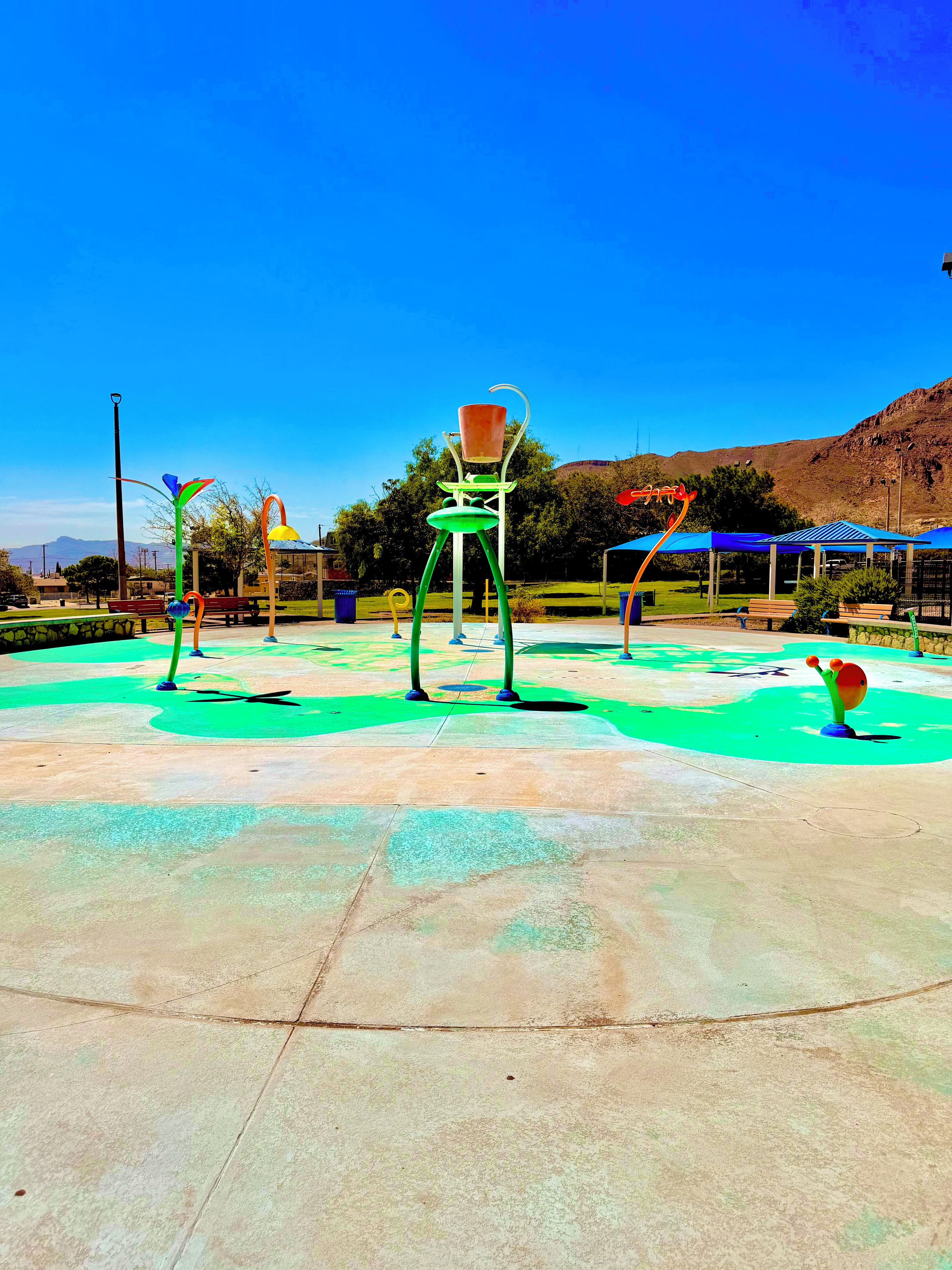 A playground with colorful structures and a clear blue sky.