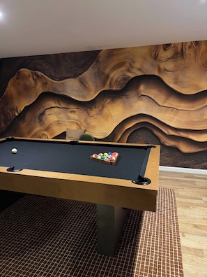 A pool table with a wooden frame and a textured wall behind it. - Stoneline Chalet - Hot Tub, Sauna, Fire Pit, Game Rm (Jewett)
