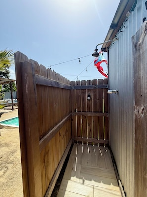 A wooden fenced area with a pool in the background. - EL Camper Retreat - Sleep 12  (Maleza Alta)