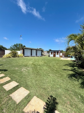 A residential property with a well-maintained lawn, a swimming pool, and a detached garage.