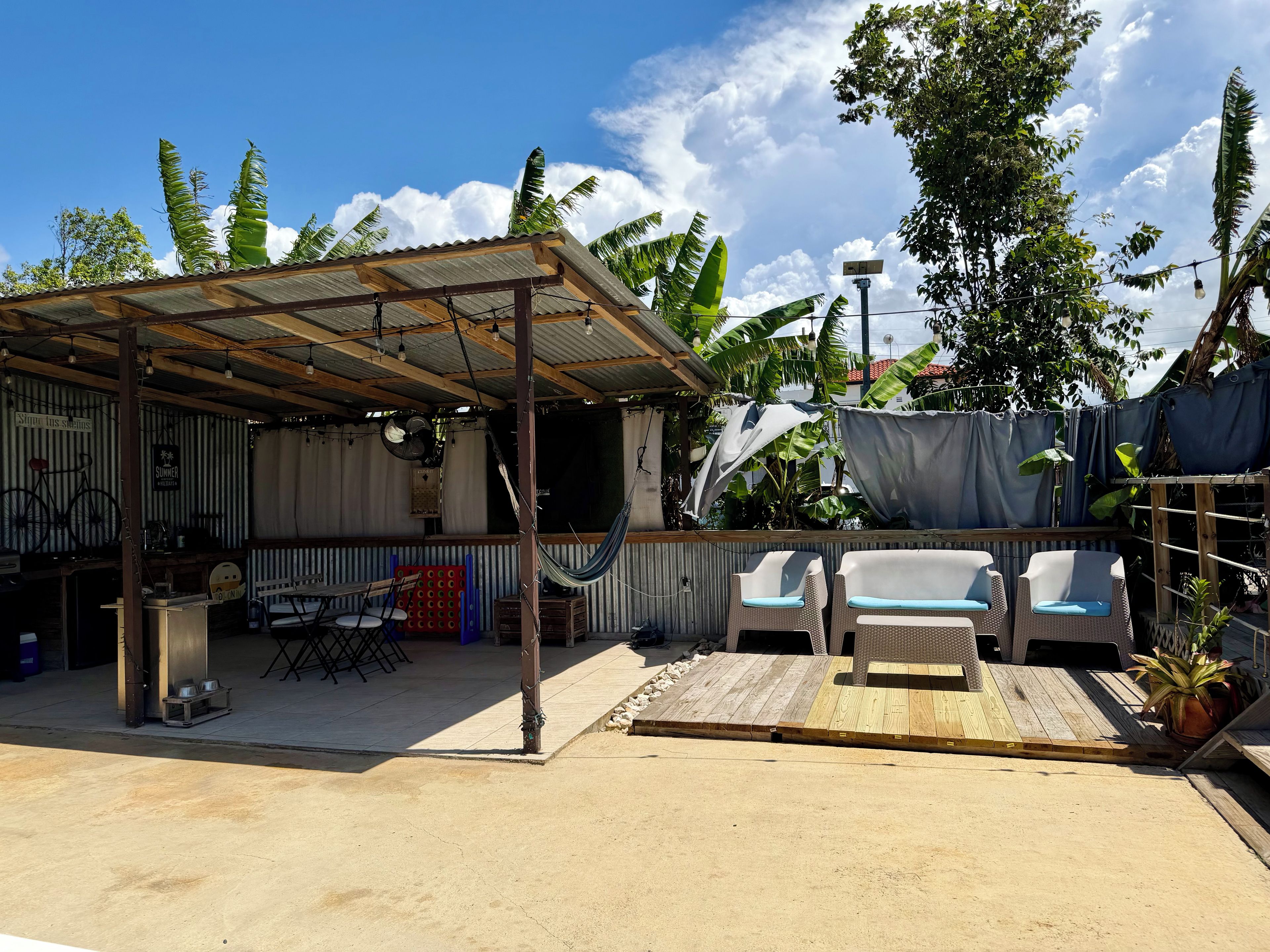 Un espacio al aire libre techado con terraza de madera, una hamaca y una bicicleta.
