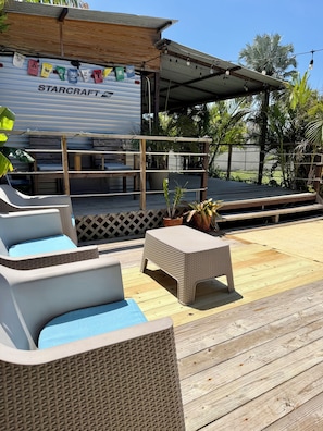 An outdoor seating area with wicker furniture and a covered stage. - EL Camper Retreat - Sleep 12  (Maleza Alta)