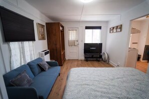 A compact room with a bed, a sofa, a television, and a kitchenette. - 2336B - Lovely Backyard Studio near UC Berkeley (Berkeley)