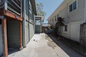A narrow driveway leading to a residential building with a garage and a fenced yard. - 2336B - Lovely Backyard Studio near UC Berkeley (Berkeley)