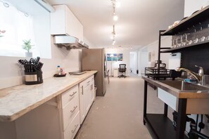 Una cocina moderna con encimera de mármol, electrodomésticos de acero inoxidable y salpicadero negro.