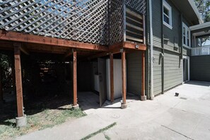 A residential building with a covered porch, a garage door, and a small concrete area. - 2336C - Ground 2B1B Unit with Laundry TV near UCB (Berkeley)