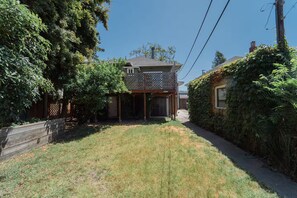 A residential property with a fenced backyard, a covered patio, and a house with a chimney. - 2336C - Ground 2B1B Unit with Laundry TV near UCB (Berkeley)