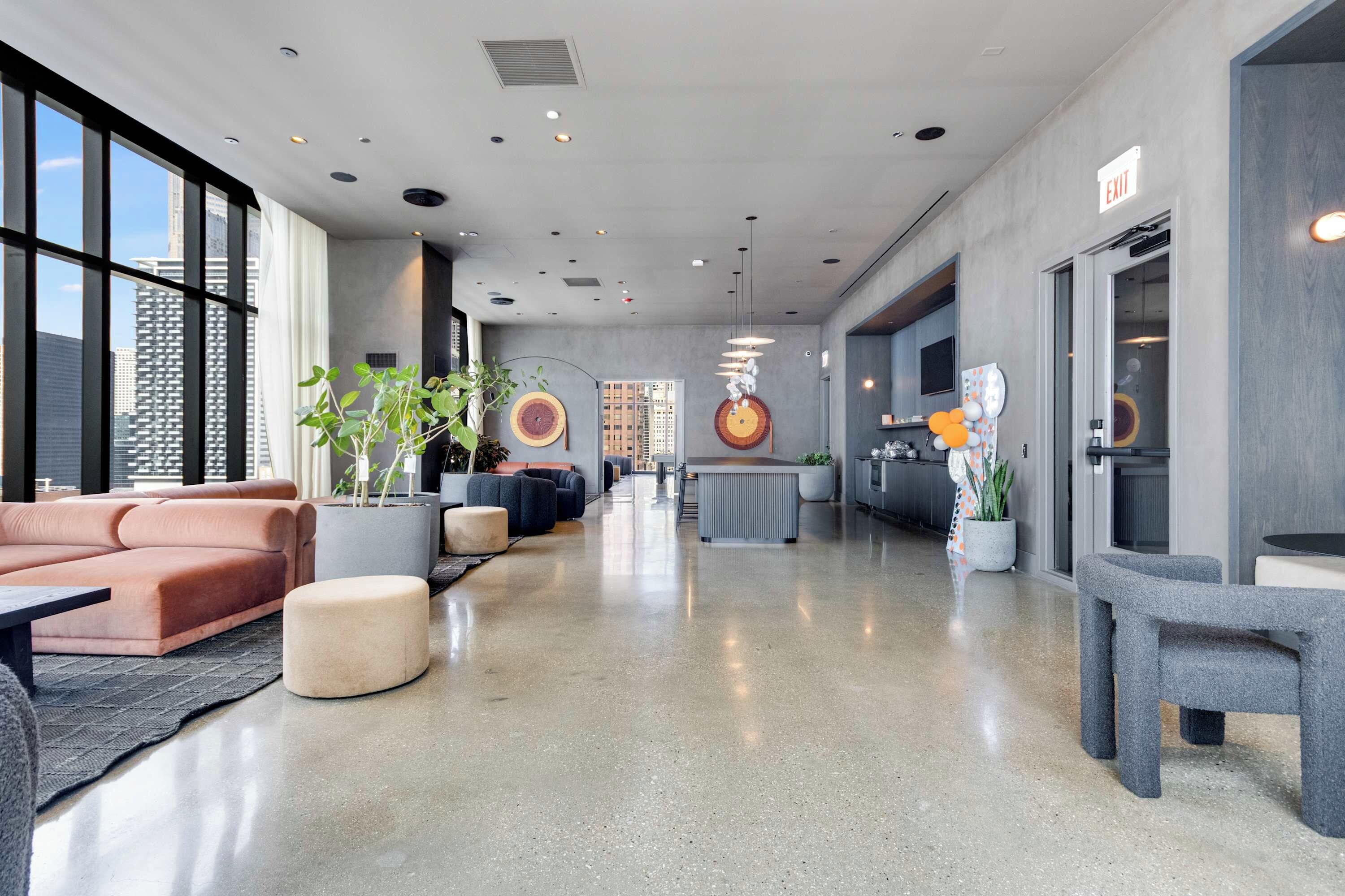 En moderne lobby med siddeområder, et receptionsskrank og store vinduer.