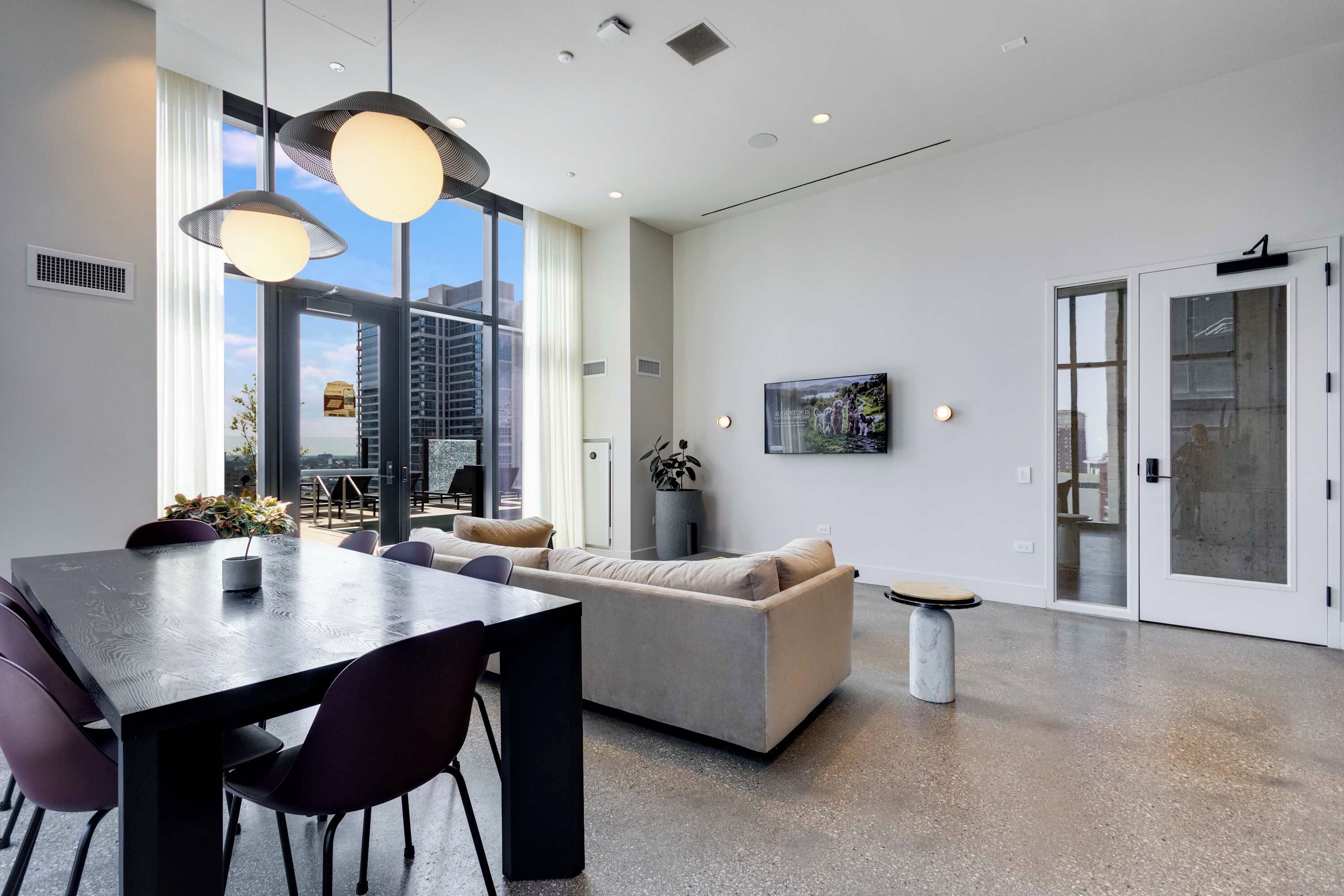Ein modernes Interieur mit Essbereich, Sofa und großem Fenster mit Blick auf die Stadt.