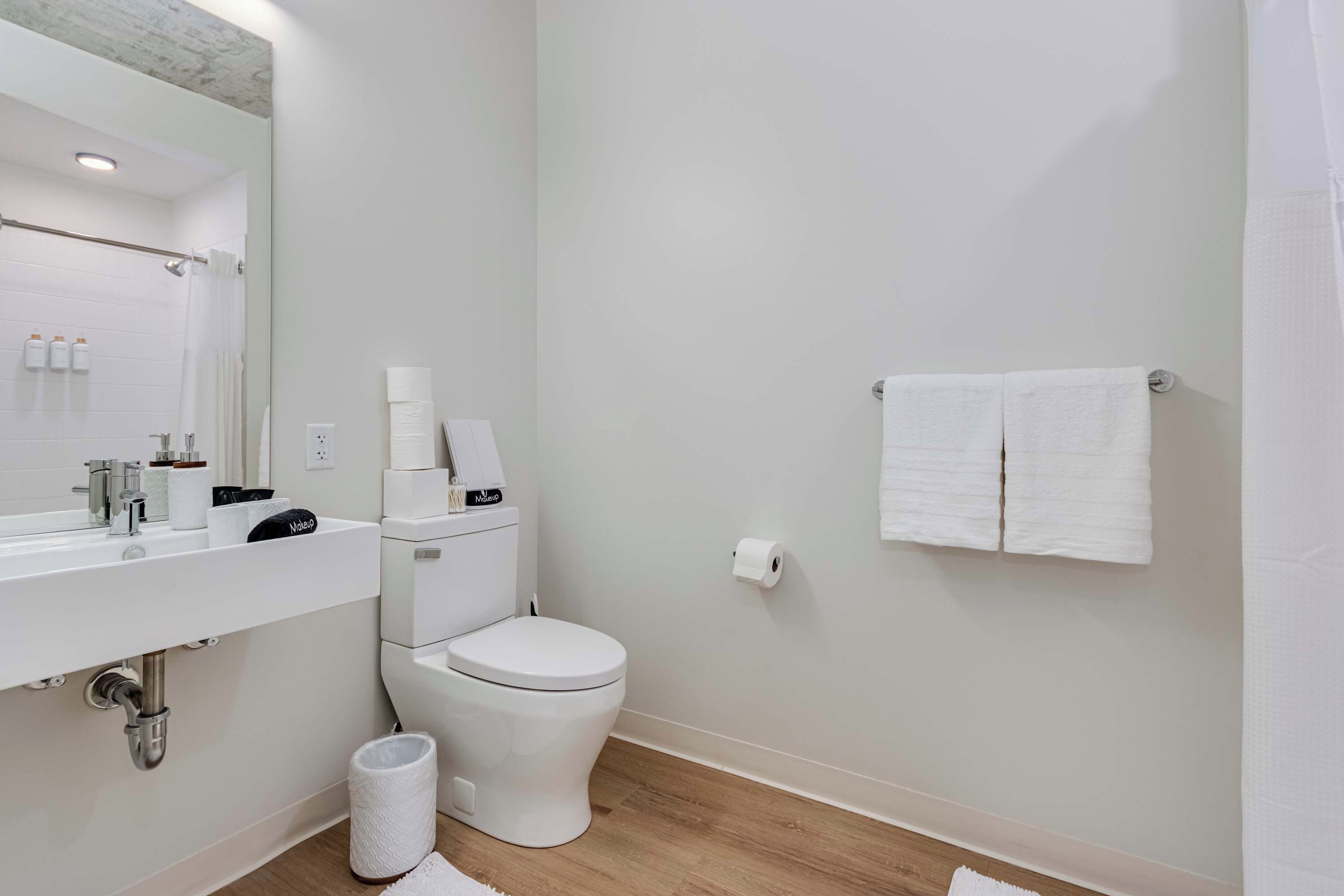 Casa de banho moderna com lavatório branco, sanita e zona de duche.