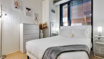 Quarto moderno com cama, mesa de cabeceira e abajur.