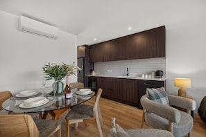 Una cocina moderna con armarios de madera oscura, encimera blanca y lavavajillas empotrado.