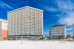 A multi-story hotel with a flat facade, located adjacent to a sandy beach. - Seawind 1808 | Gulf-front with Pools + Hot Tub (Gulf Shores)