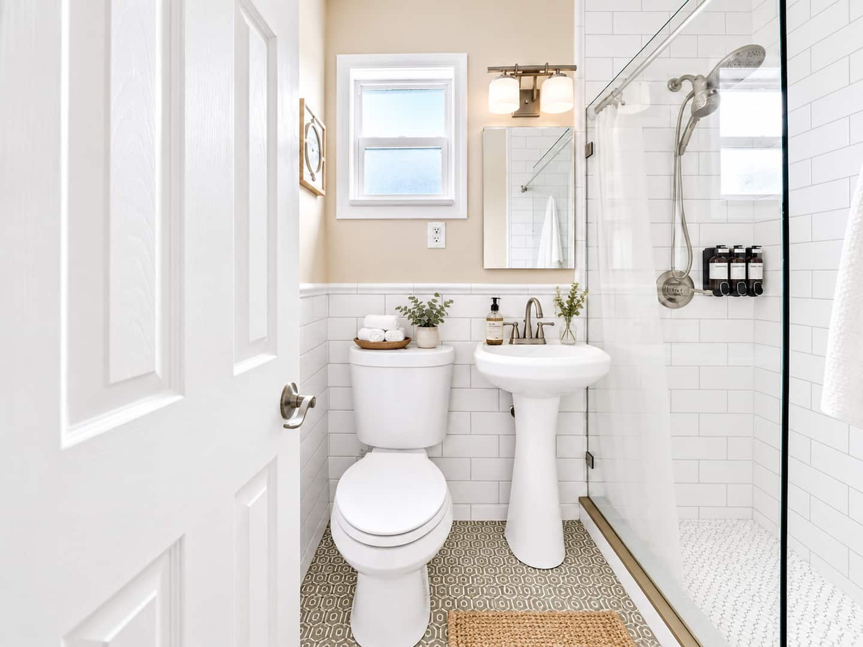 Un baño con inodoro, lavamanos, ducha y ventana.