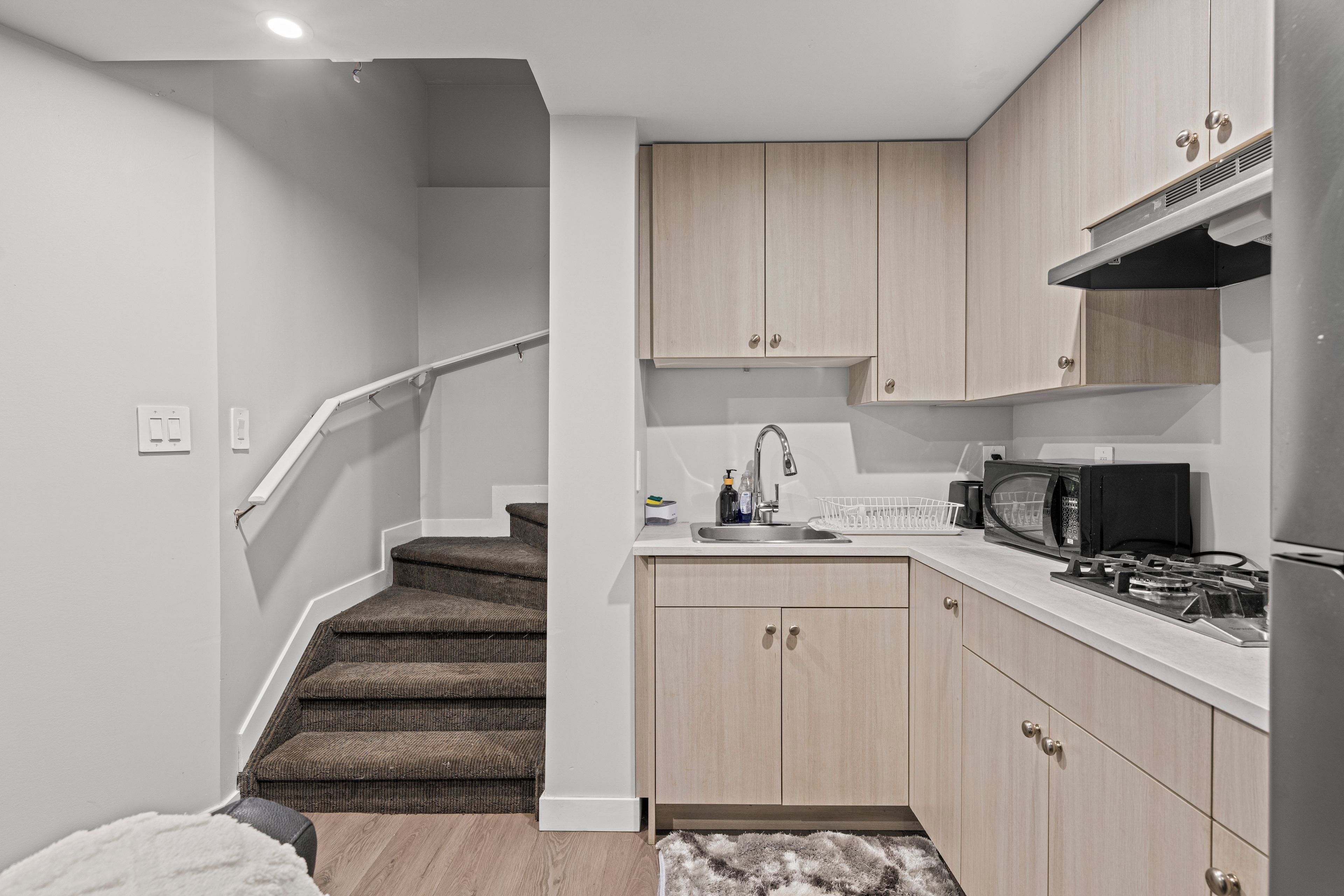 A compact kitchen with a microwave, stove, and sink.