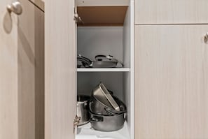 A kitchen cabinet with two shelves, one of which contains a pot and a pan. - Beautiful King Size Bedroom BM Unit Close to Downtown Edm,Fast Wifi, Private Ent (Edmonton)