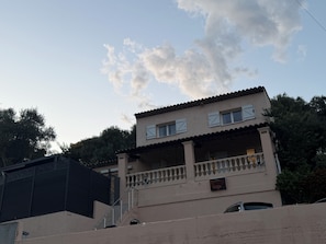 Ein zweistöckiges Gebäude mit Balkon, der Hausnummer '248' und einem Basketballkorb.