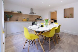 A modern kitchen with a dining area. - Rhondda Retreat 3-Bedroom House (Tonypandy)