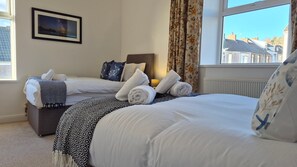 Ein Hotelzimmer mit zwei Betten, Blick auf den Nachthimmel und einem gerahmten Bild an der Wand.