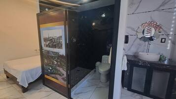 Una habitación con una cama, un baño con inodoro y lavamanos.